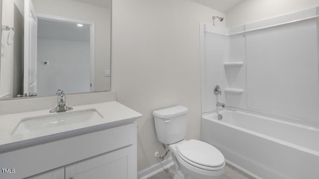 bathroom with toilet, baseboards,  shower combination, and vanity