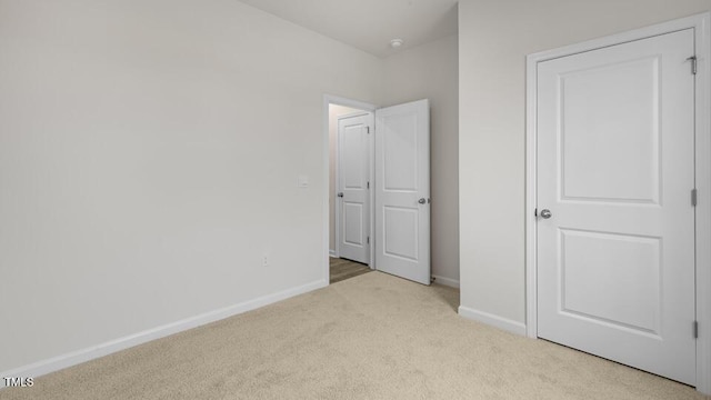 unfurnished bedroom featuring carpet flooring and baseboards