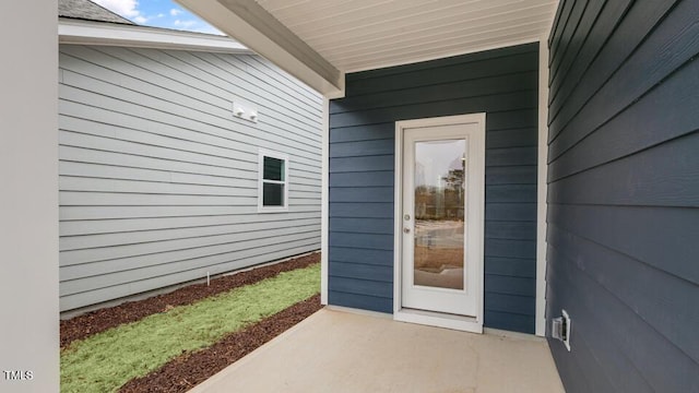 view of exterior entry with a patio