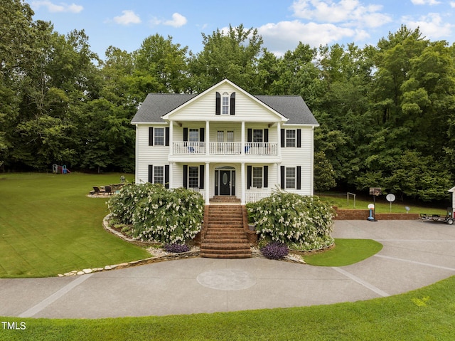 greek revival house with a balcony and a front lawn