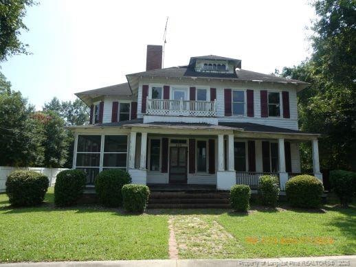 view of front of property with a sunroom and a front lawn