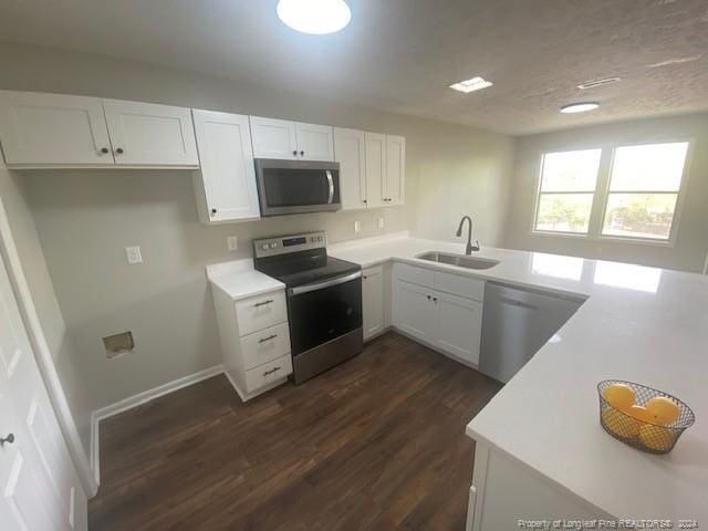 kitchen featuring white cabinetry, appliances with stainless steel finishes, sink, and dark wood-type flooring