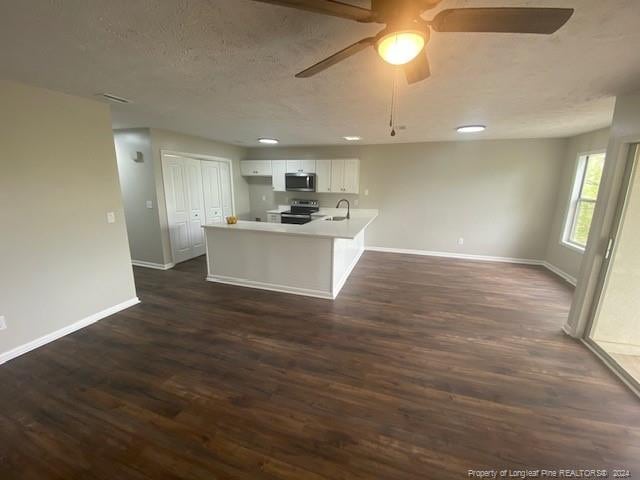 kitchen featuring sink, dark wood-type flooring, stainless steel appliances, white cabinets, and kitchen peninsula