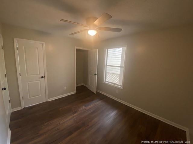 unfurnished bedroom with dark hardwood / wood-style floors and ceiling fan