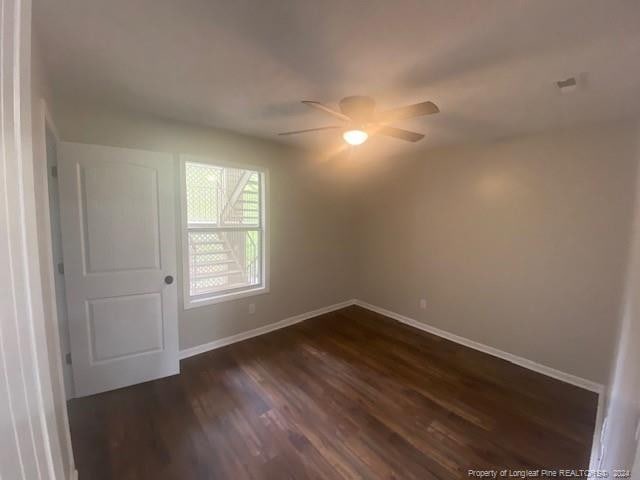 spare room featuring dark hardwood / wood-style floors and ceiling fan