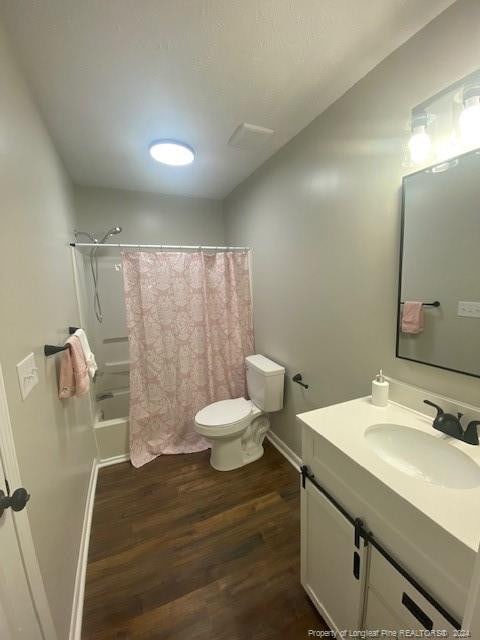 full bathroom with shower / tub combo with curtain, wood-type flooring, toilet, and vanity