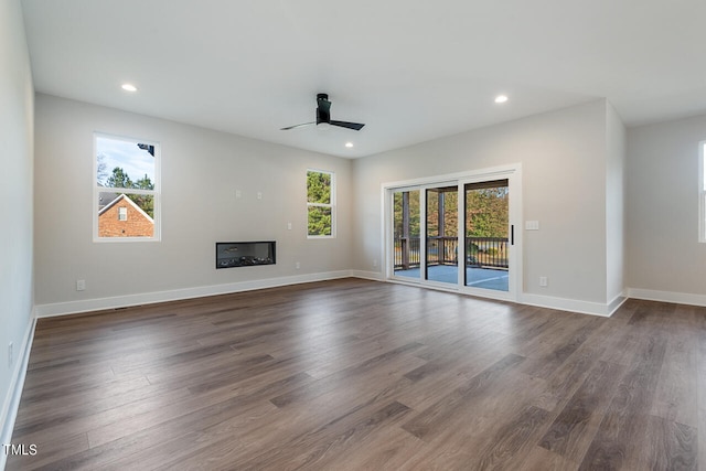 unfurnished living room featuring dark hardwood / wood-style floors and ceiling fan