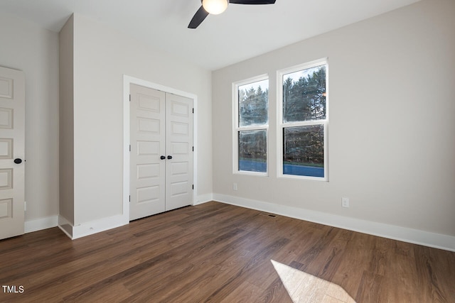 unfurnished bedroom with ceiling fan, hardwood / wood-style flooring, and a closet