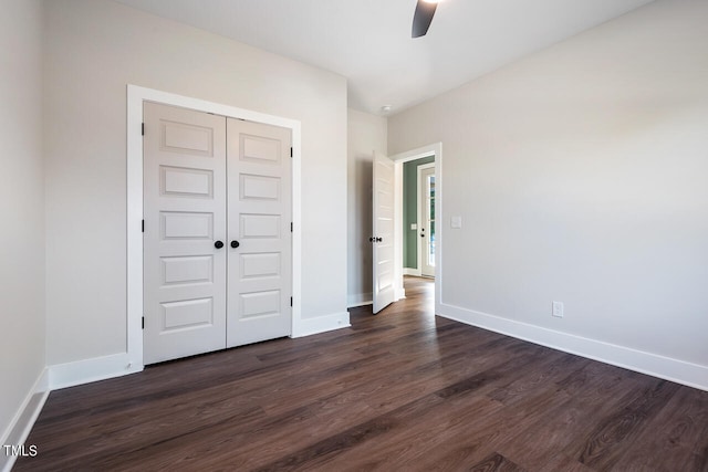 unfurnished bedroom with dark hardwood / wood-style flooring, a closet, and ceiling fan