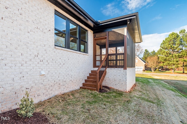 view of exterior entry with a yard