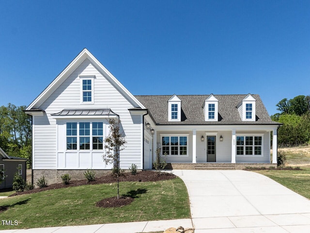 6052 Scalybark Rd, Durham, NC 27712 - view of front facade featuring a standing seam roof, a porch, roof with shingles, and a front yard