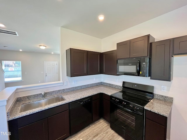 kitchen with sink, dark brown cabinets, kitchen peninsula, light hardwood / wood-style floors, and black appliances