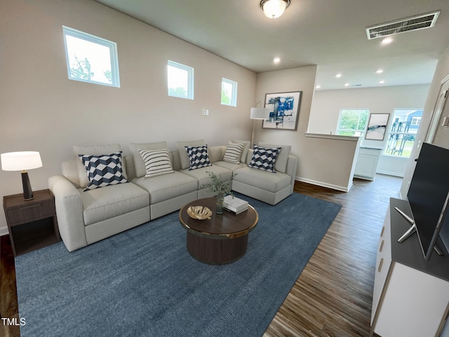 living room with dark wood-style floors, visible vents, plenty of natural light, and baseboards