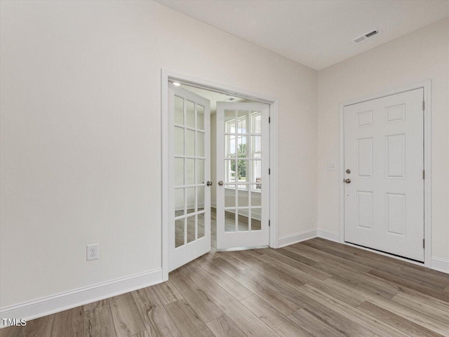 interior space with visible vents, baseboards, and wood finished floors