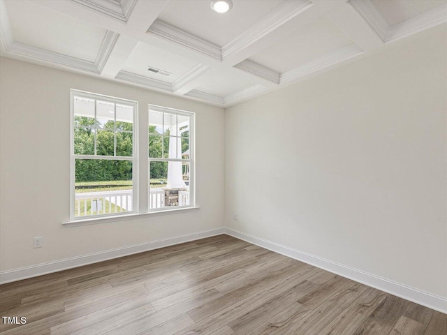 spare room featuring light wood finished floors, coffered ceiling, and baseboards