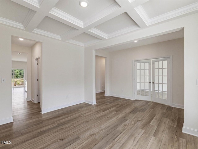 empty room with baseboards, coffered ceiling, wood finished floors, and french doors