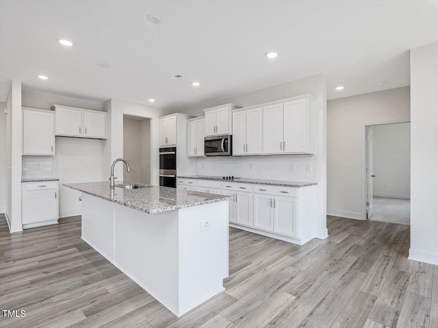 kitchen with stainless steel appliances, white cabinets, and a sink