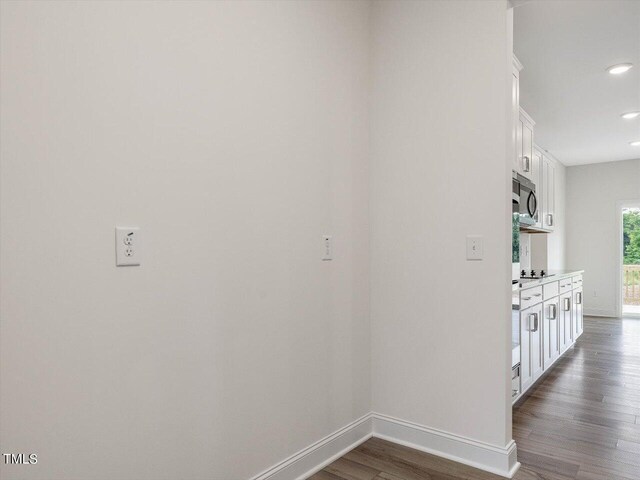 corridor featuring dark wood-style floors, recessed lighting, and baseboards