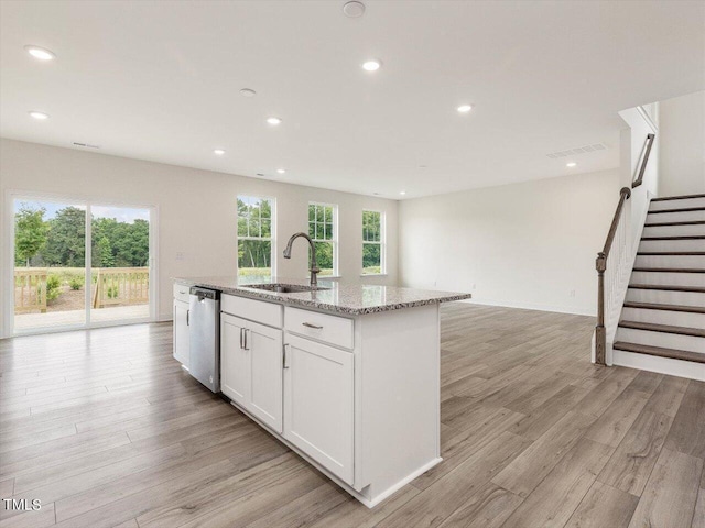 kitchen featuring dishwasher, light wood-style flooring, a sink, and a wealth of natural light