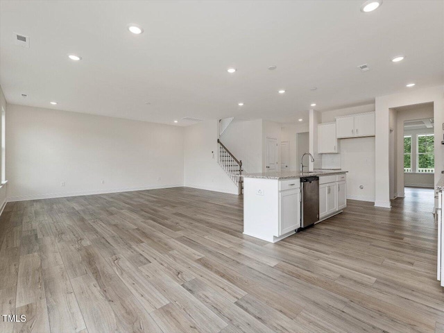 kitchen with open floor plan, visible vents, a sink, and stainless steel dishwasher