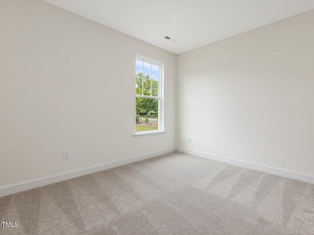 carpeted spare room with visible vents and baseboards