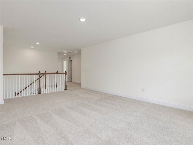 empty room featuring baseboards, recessed lighting, and light colored carpet