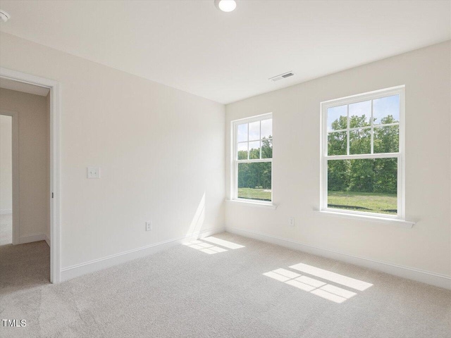 unfurnished room featuring carpet floors, visible vents, and baseboards