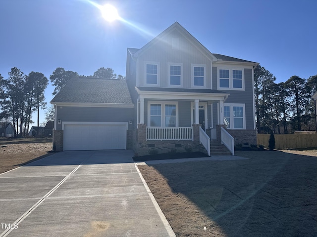 view of front of home featuring a porch, driveway, and an attached garage