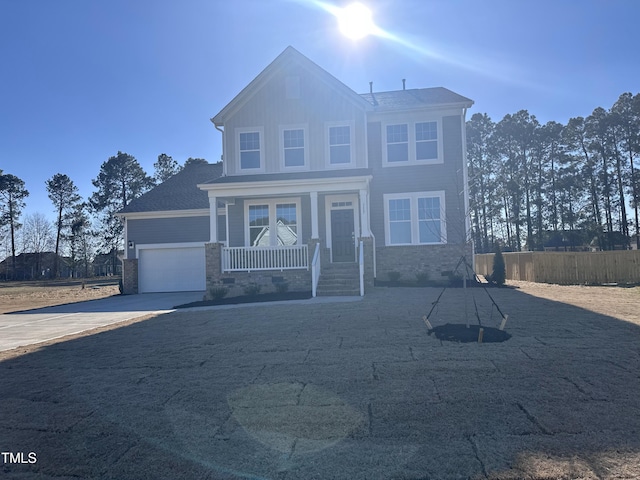 view of front of house with a garage, covered porch, fence, and concrete driveway