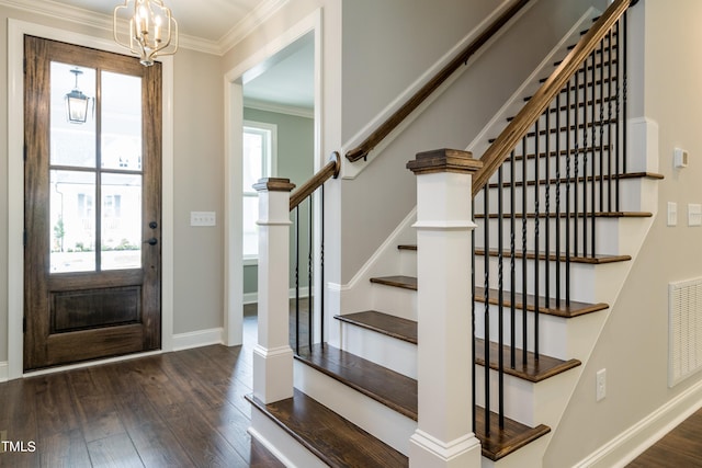 foyer entrance featuring ornamental molding, wood finished floors, visible vents, and baseboards