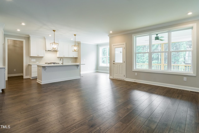 kitchen featuring light countertops, dark wood-style flooring, backsplash, and crown molding