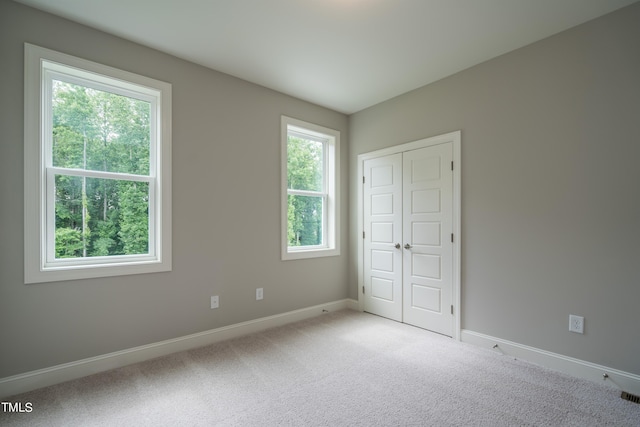 unfurnished bedroom with carpet, visible vents, baseboards, and a closet