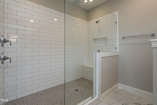 full bath featuring a walk in shower, marble finish floor, and baseboards