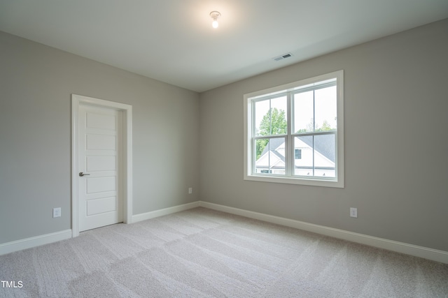 unfurnished room featuring light carpet, visible vents, and baseboards