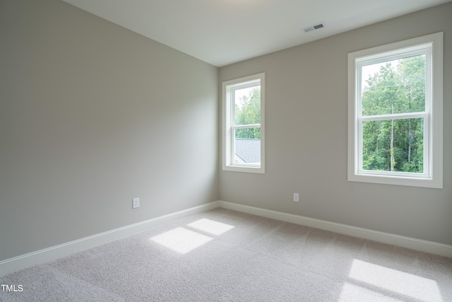 carpeted spare room with baseboards and visible vents