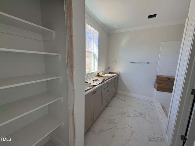 full bath with baseboards, marble finish floor, double vanity, and crown molding