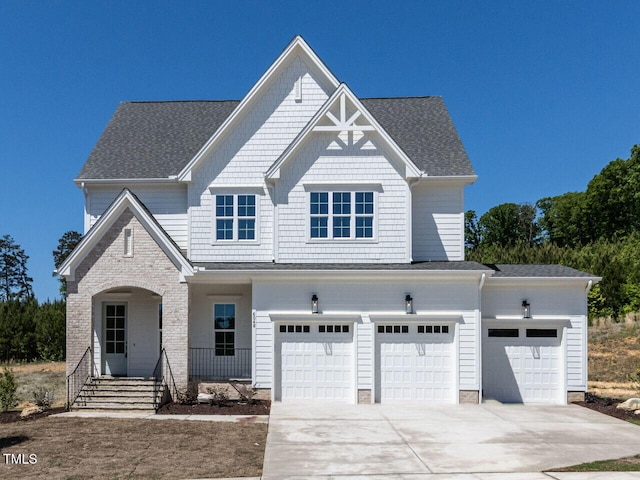 craftsman house featuring covered porch, an attached garage, driveway, and a shingled roof