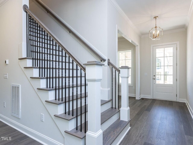 entrance foyer with stairway, a chandelier, wood finished floors, and visible vents