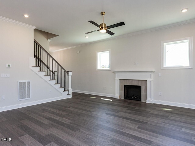 unfurnished living room with ceiling fan, dark wood-style flooring, visible vents, stairway, and ornamental molding