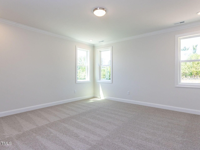 empty room featuring crown molding, baseboards, light carpet, and visible vents