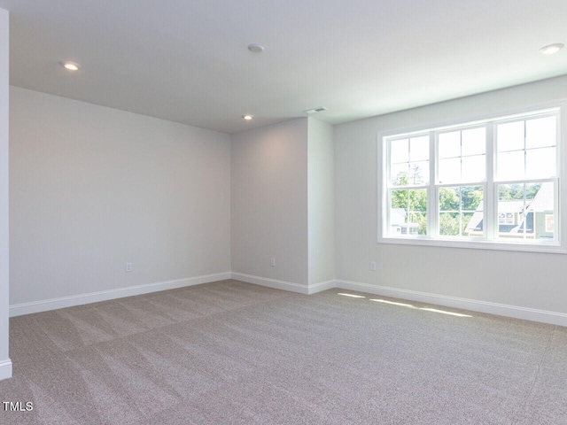 spare room with recessed lighting, baseboards, and light carpet