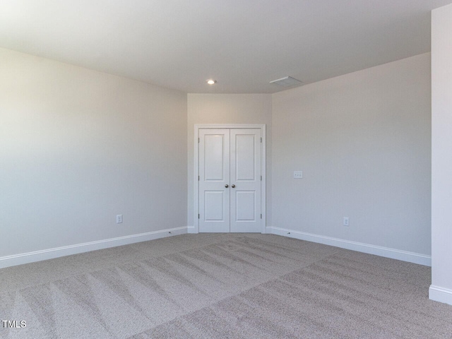 carpeted spare room featuring recessed lighting and baseboards