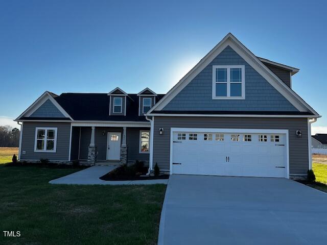 craftsman-style house featuring a front yard and concrete driveway