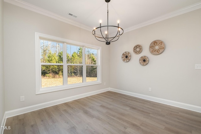 unfurnished dining area with hardwood / wood-style flooring, a notable chandelier, and ornamental molding