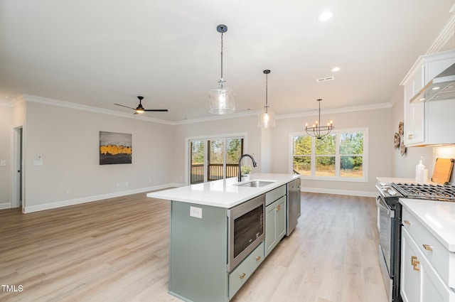 kitchen featuring white cabinetry, sink, stainless steel appliances, light hardwood / wood-style flooring, and a center island with sink