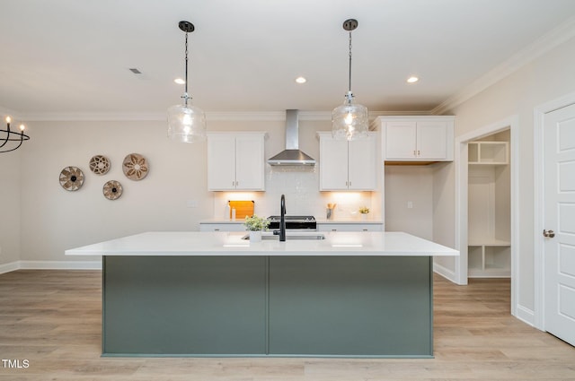 35 Uptown Rd, Zebulon, NC 27597 - kitchen with wall chimney exhaust hood, white cabinets, light countertops, an island with sink, and crown molding