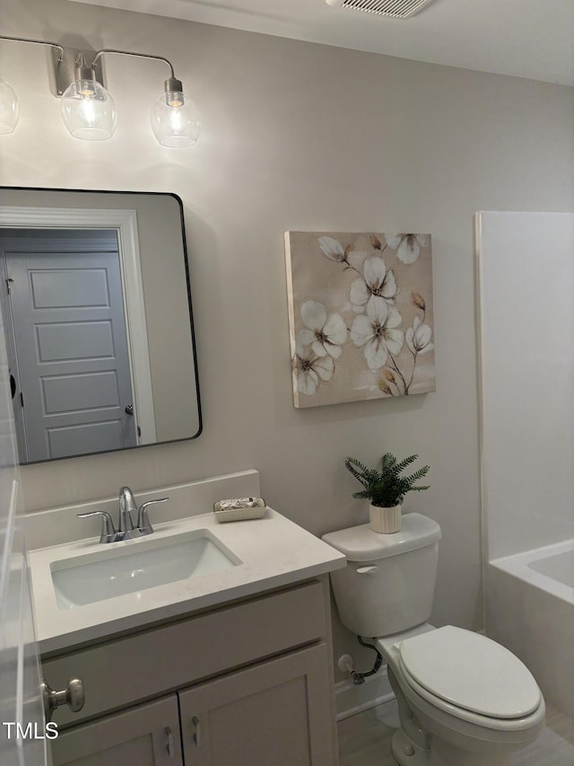 bathroom featuring a bathing tub, vanity, and toilet