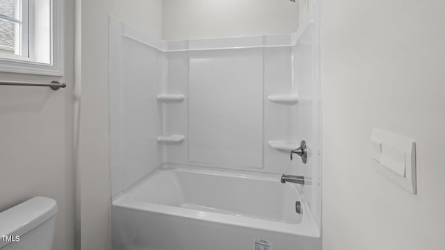 bathroom featuring tub / shower combination and toilet