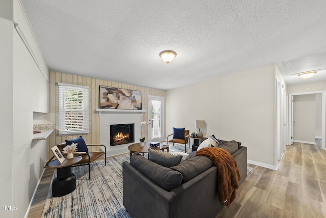 603 E Park St, Cary, NC 27511 - living area with a fireplace, a textured ceiling, light wood-type flooring, and attic access