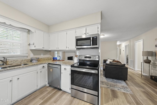 603 E Park St, Cary, NC 27511 - kitchen with stainless steel appliances, light wood finished floors, and white cabinetry